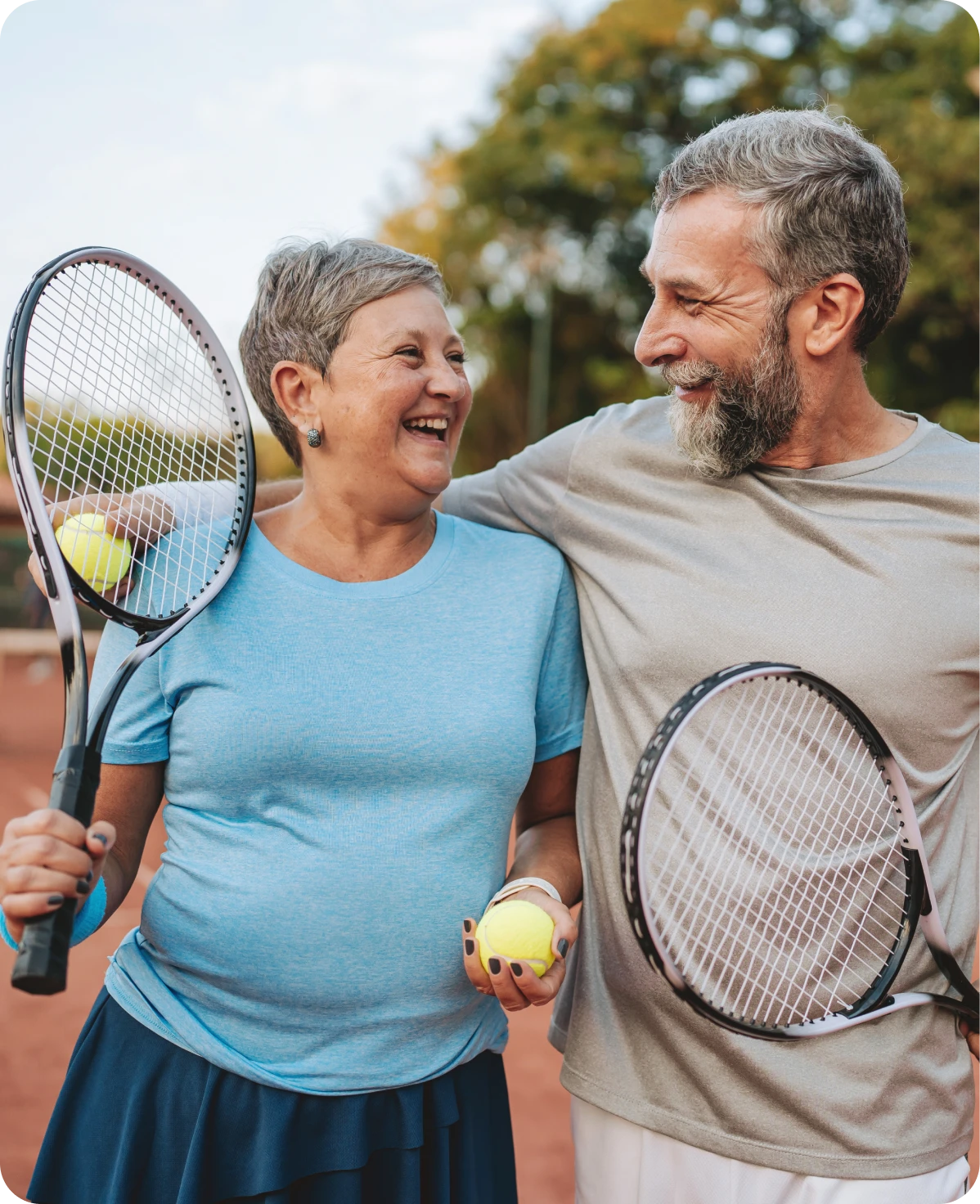 Happy couple holding tennis rackets together